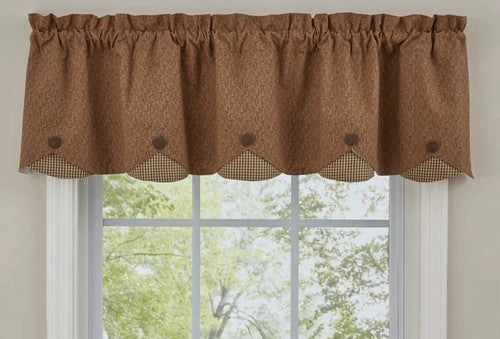 Brown scalloped valance with black dots above a window
