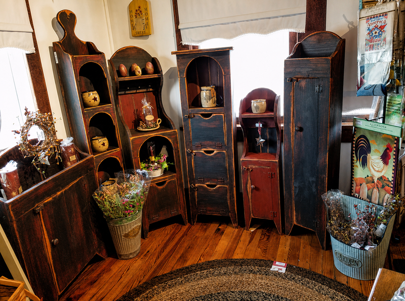 Vintage wooden furniture and decor items in a room with wooden floor.
