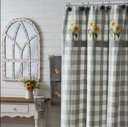 Bathroom with checkered curtain, mirror, and sunflower-themed towels
