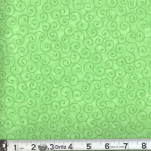 Green fabric with swirl pattern and a ruler at the bottom for scale.
